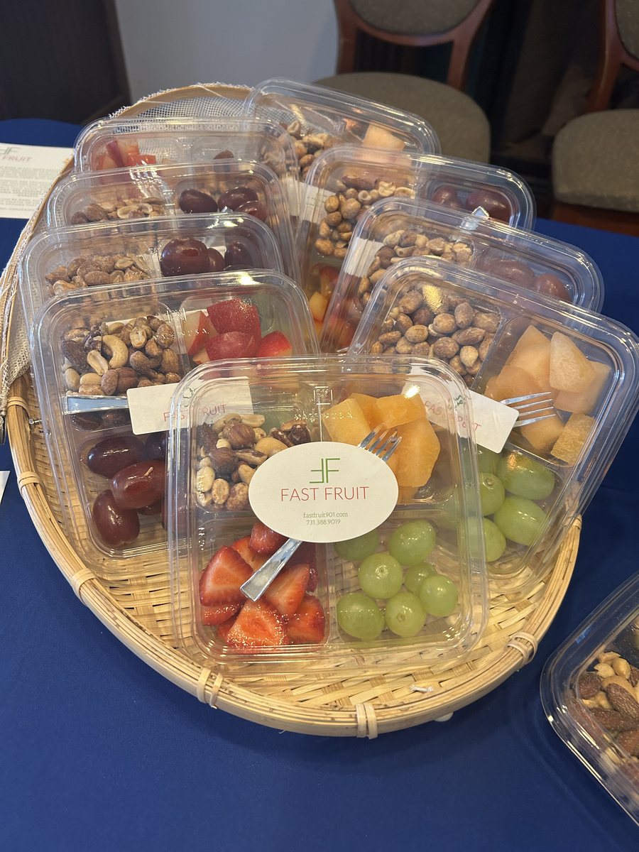 Close-up of packaged Fast Fruit containers with fruit, nuts, and a visible Fast Fruit label displayed in a basket.